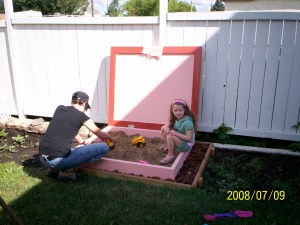 MidKid and BabyDaughter in the pink sandbox their Daddy built.